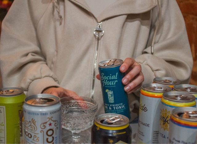 holding a canned cocktail