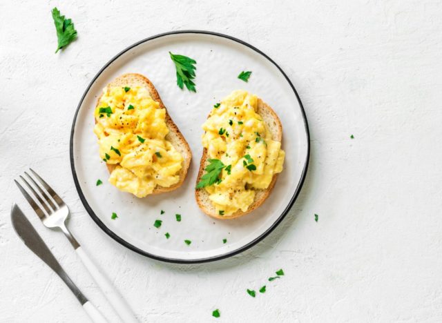 eggs and toast on a plate with a knife and fork