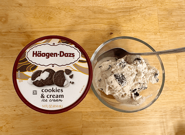 a container of haagen dazs next to a bowl of ice cream