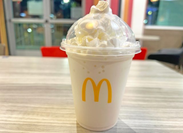 A vanilla milkshake in a see-through plastic cup from McDonald's