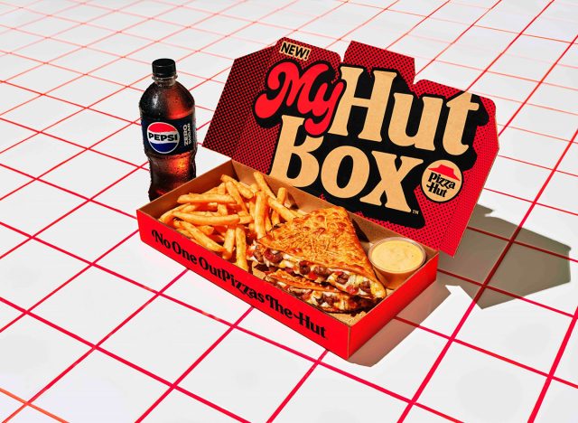 Pizza Hut's My Hut Box meal kit, including the new Cheeseburger Melt and a bottle of Pepsi, on a checkered background