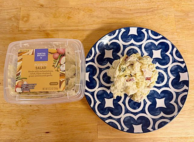 a container of tabitha brown potato salad next to a dish of potato salad