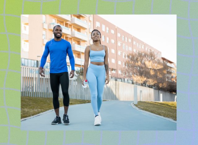 fit couple walking outdoors on paved path