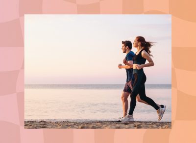 happy couple running on the beach at sunset