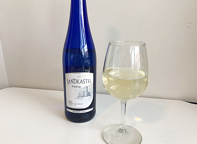 a bottle of riesling next to a glass of white wine