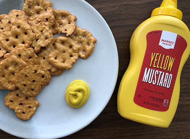 a bottle of market pantry mustard next to a plate of pretzels 