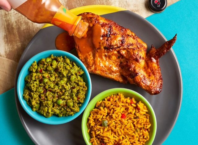 nando's chicken on a plate with bowls of rice and macho pies