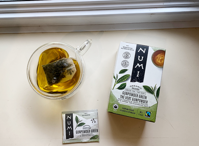 numi green tea box next to mug