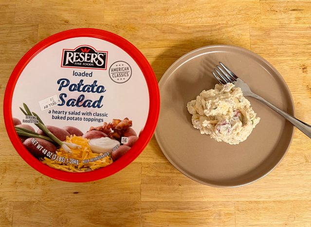 a container of loaded potato salad next to a dish of potato salad 