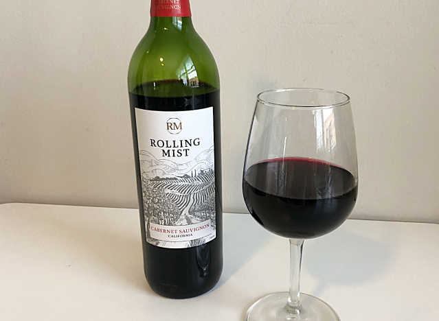 bottle of rolling mist red wine next to a glass of red wine