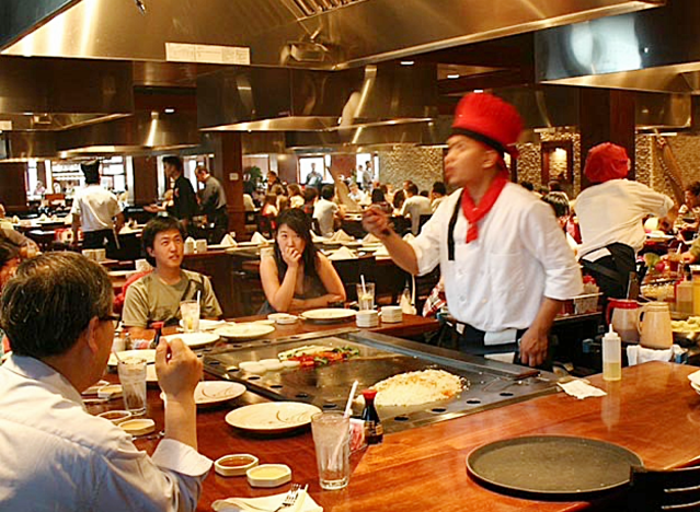 a table full of diners with hibachi chef at a sakura japanese steakhouse