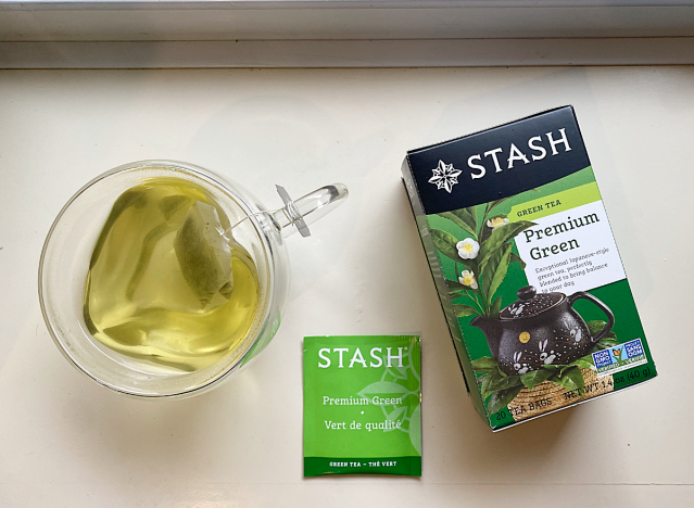stash green tea in mug next to a box 