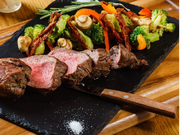 steak with veggies on platter
