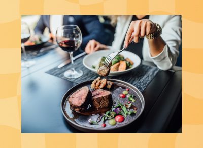 close-up of woman and man eating steak dinner at restaurant