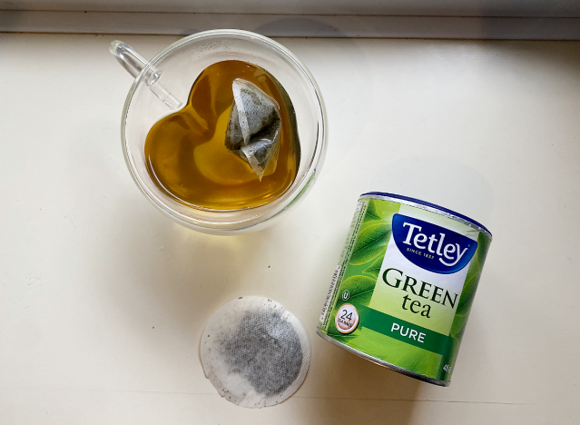 a can of tetley green tea next to a mug