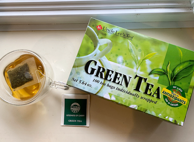 a mug of uncle lee's green tea next to box 
