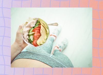 woman holding a salad with chicken and vegetables