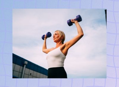 blonde woman lifting purple dumbbells, doing shoulder presses outdoors