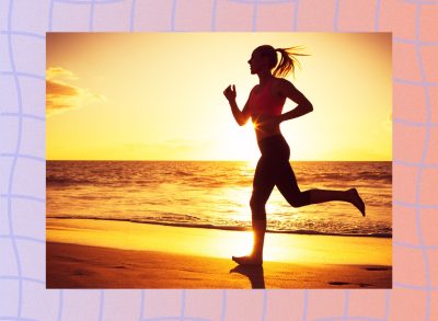 fit woman running on beach at sunset by the water