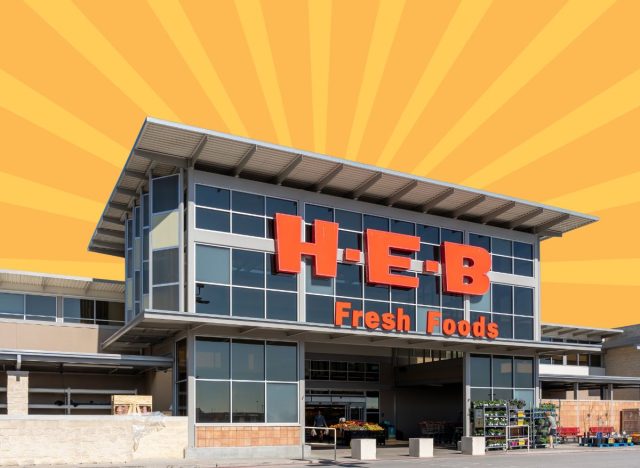 The storefront of H-E-B grocery store set against a vibrant orange-yellow background
