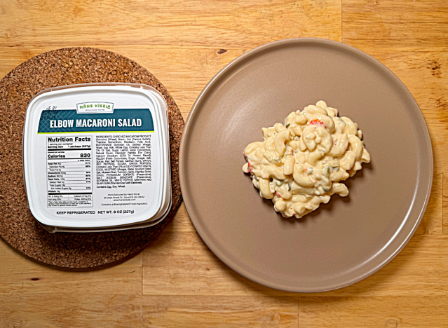 a container of hans kissle macaroni salad next to a plate of it 