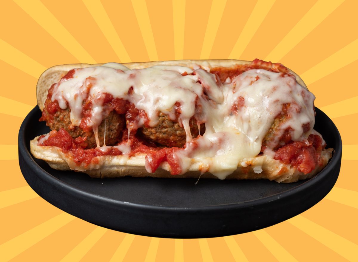 A cheesy, saucy meatball sub set against a colorful background