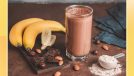 chocolate protein shake made with banana almonds and protein powder on a wooden table