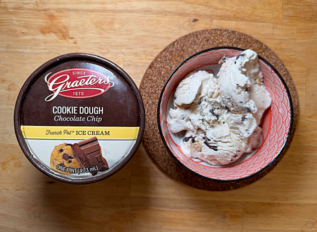 a container of graeters cookie dough ice cream next to a bowl of it 