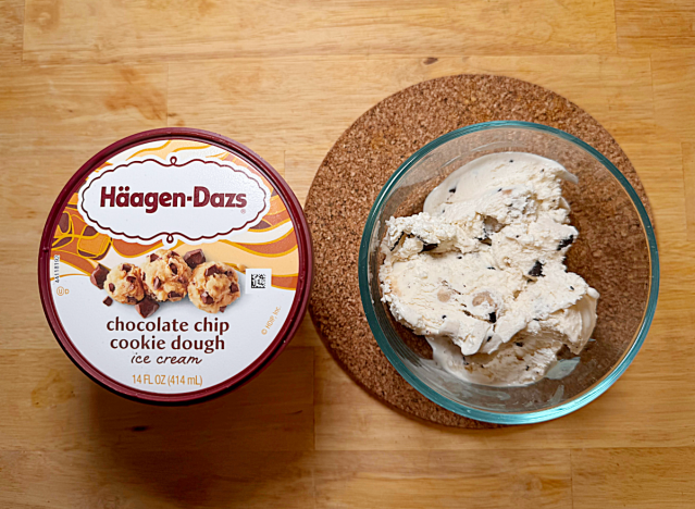 a container of haagen dazs cookie dough next to a bowl of it 