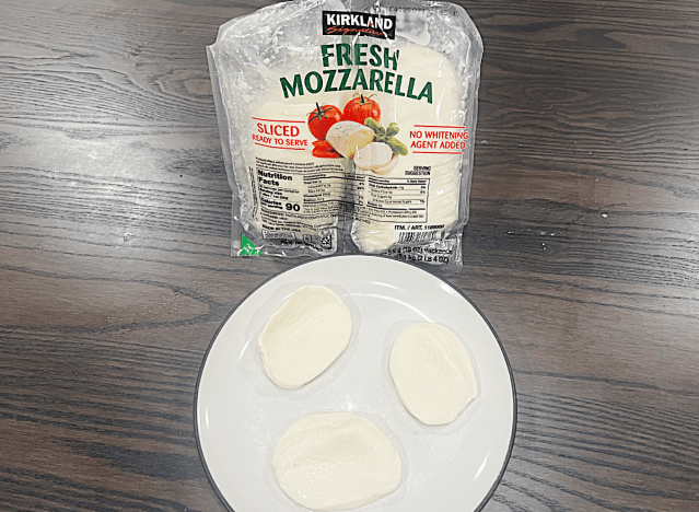 a bag of kirkland fresh mozzerella next to a plate of slices 