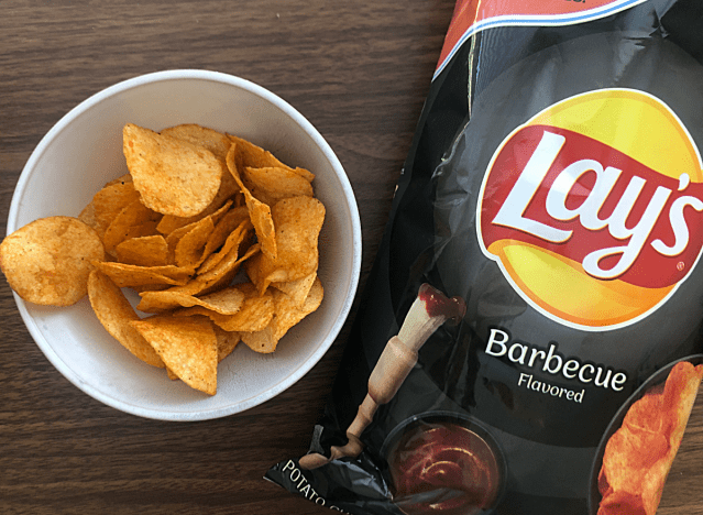 a bag of lay's barbecue next to a bowl of chips