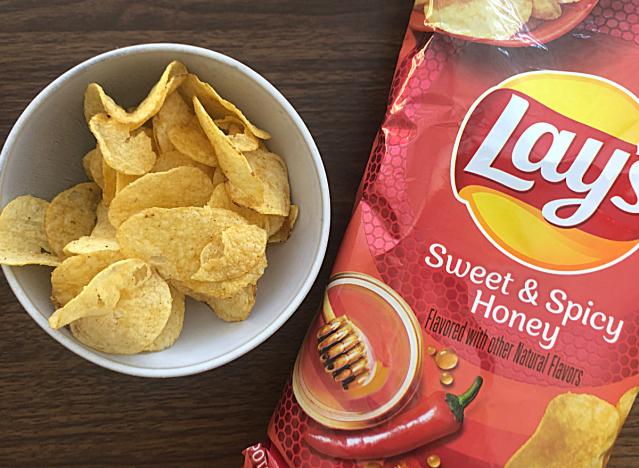 a bag of sweet and spicy honey lays next to a bowl of chips