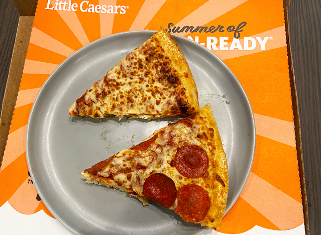 two slices of little caesars pizza on top of a box 