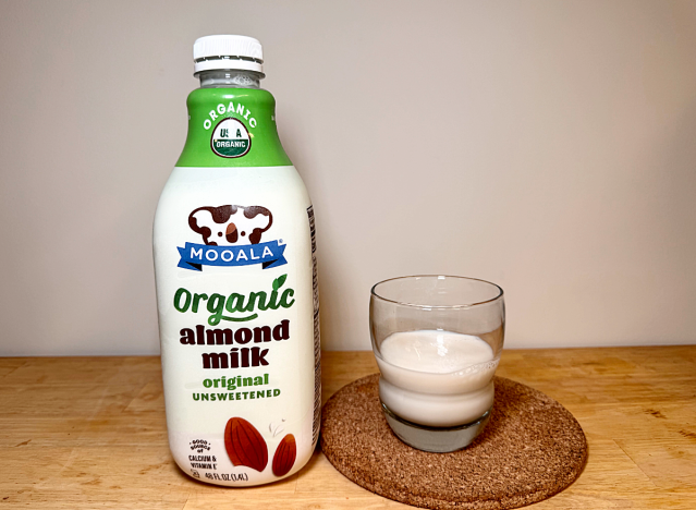 mooala almond milk container next to a glass of it 