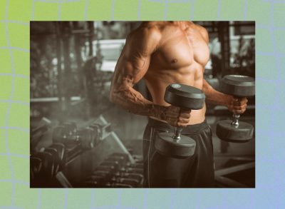 close-up of muscular man holding dumbbells at the gym