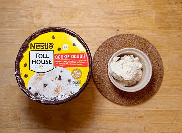 a container of nestle cookie dough ice cream next to a bowl of it 