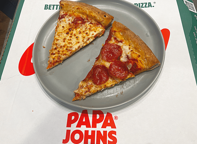 two slices of papa johns pizza on a box 