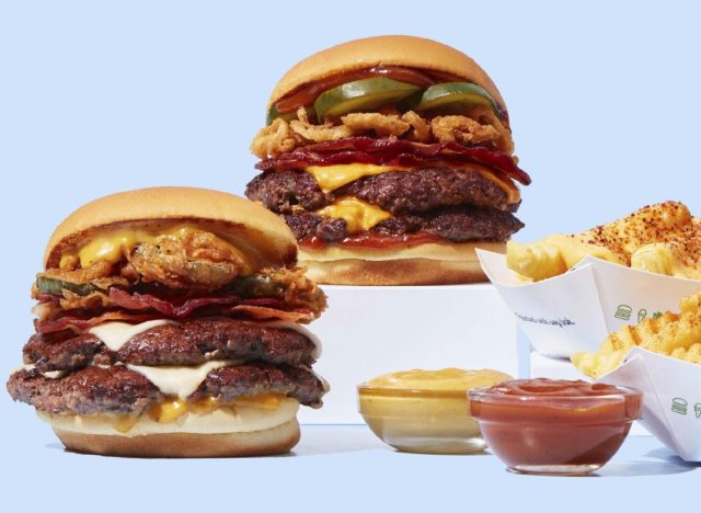 shake shack's smoky classic bbq burger, bbq burger with fried pickles, and bbq-fries with dipping sauces on a light blue background