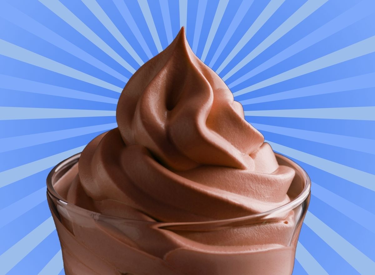 A cup of chocolate soft serve ice cream set against a vibrant blue background.