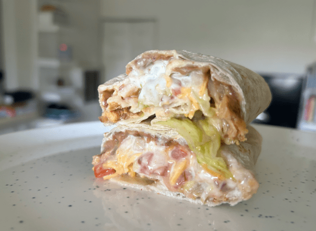 a taco bell burrito cut open on a countertop 