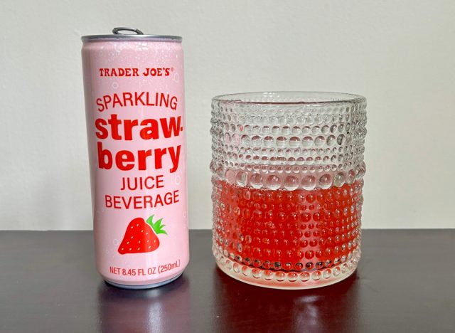 can of trader joe's sparkling strawberry juice next to a glass of the beverage