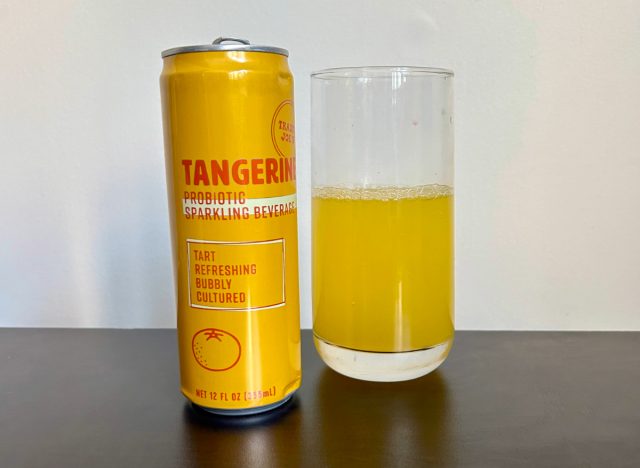 can of trader joe's tangerine probiotic sparkling beverage next to a glass of the drink