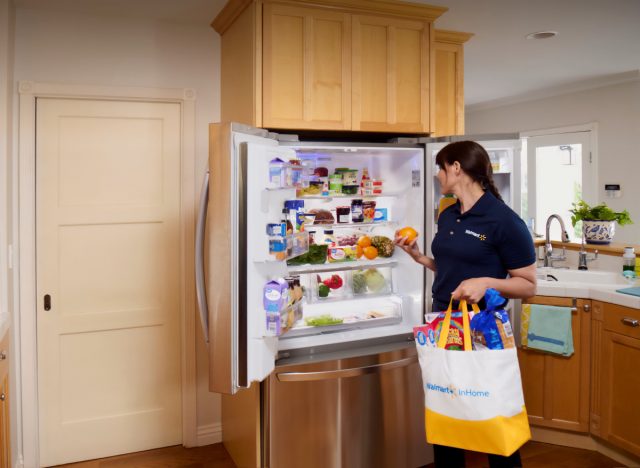 walmart associate stocking customer's fridge through inhome delivery service
