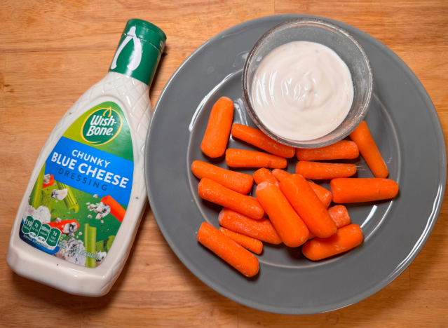 a bottle of wishbone chunky blue cheese next to carrots on plate 