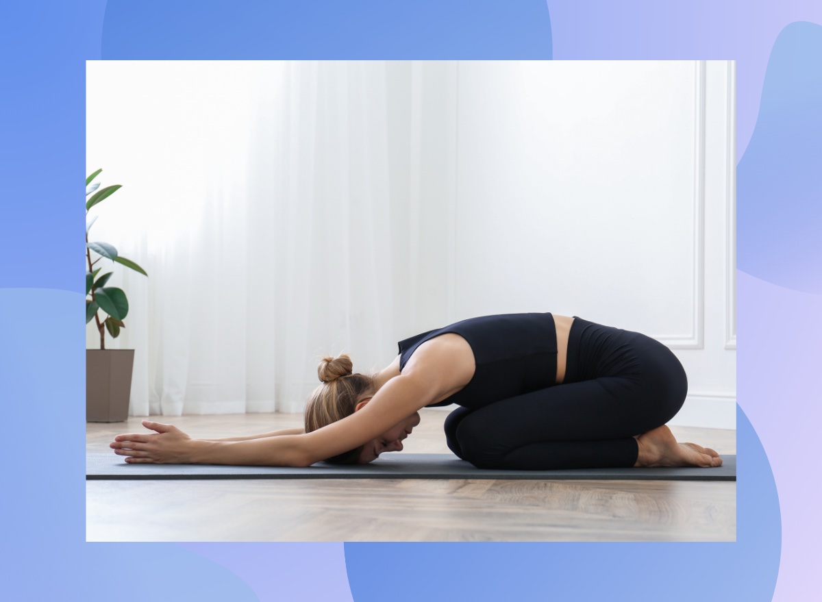 blonde woman doing child's pose in bright living space on yoga mat