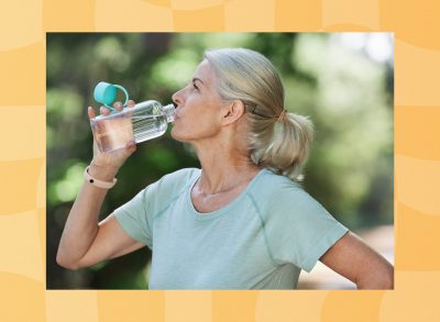 mature woman drinking water during workout outdoors
