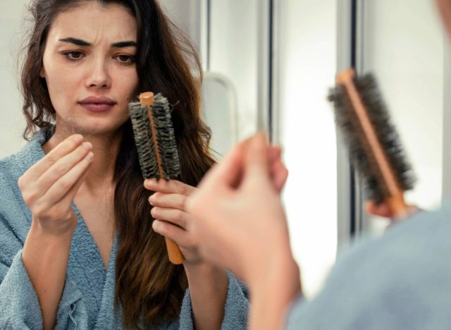 woman noticing her hair falling out after shower