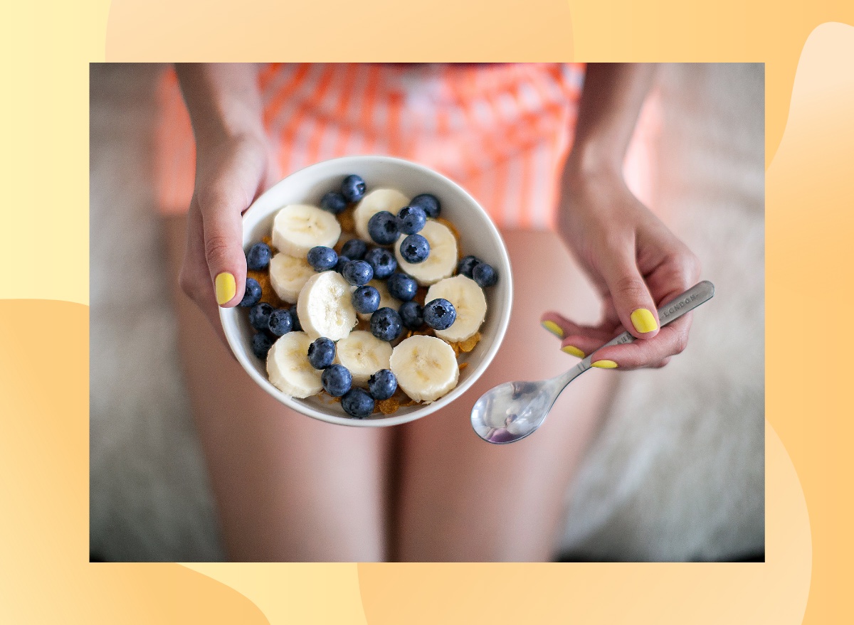 close-up woman holding bowl of blueberries and bananas