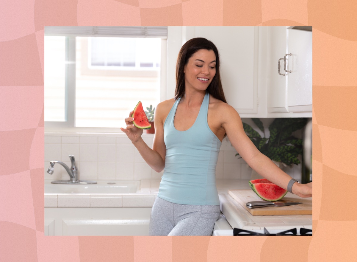 fitness woman holding fresh watermelon in kitchen