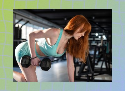 fit red-haired woman lifting weights at the gym